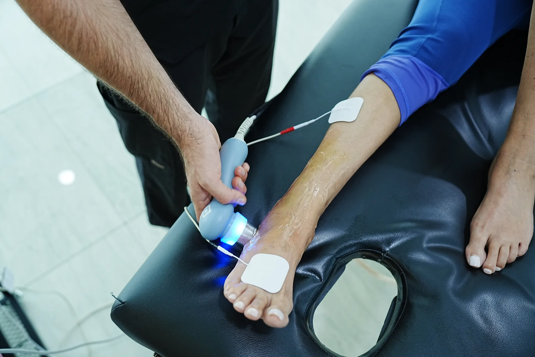 Atención de fisioterapia con equipo terapéutico en el tobillo